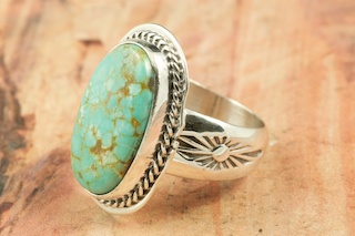 Genuine Number 8 Turquoise set in Sterling Silver Ring. The Number 8 mine is located in Eureka County Nevada. Since 1976 there has been no Number 8 Turquoise mined. There is however, an existing stock pile that Mr. Dowell Ward, the last owner of the Number 8 mine, had stocked away for later sorting. The Turquoise is a collector's item--because once the reserve is gone there will be no more material released onto the market. The Gold Mining Company owns the claim to the Number 8 mine and it has been swallowed up by the gold mining operations. This is some of the last Number 8 Turquoise to be had and will be a great addition to your collection. Created by Navajo Artist Lucy Valencia. Signed L. J. by the artist.